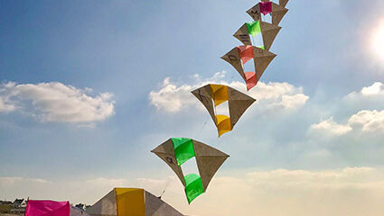 Het oplaten van een vliegertrein op het strand.